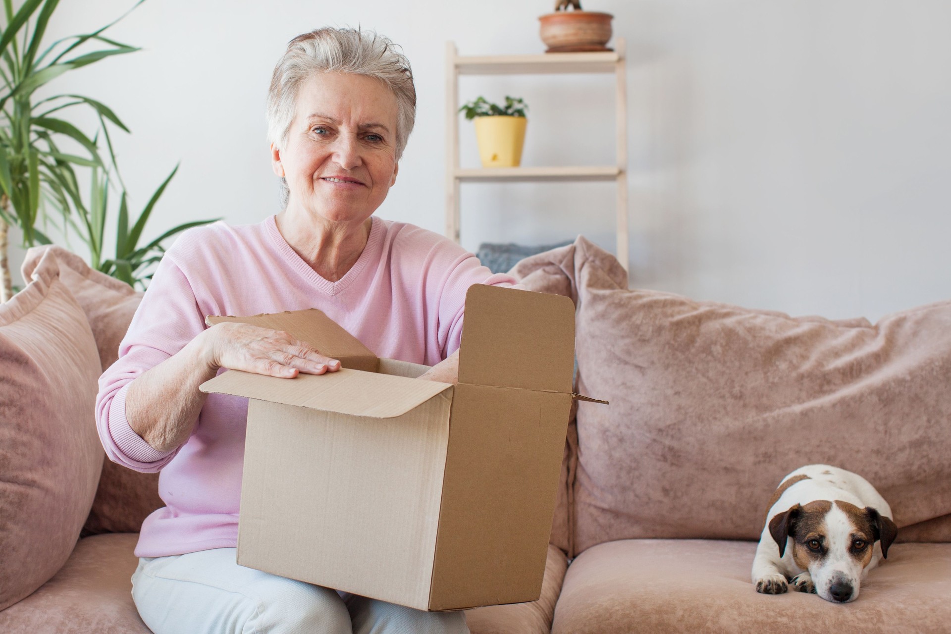 Smiling older adult mature woman customer unpacking parcel